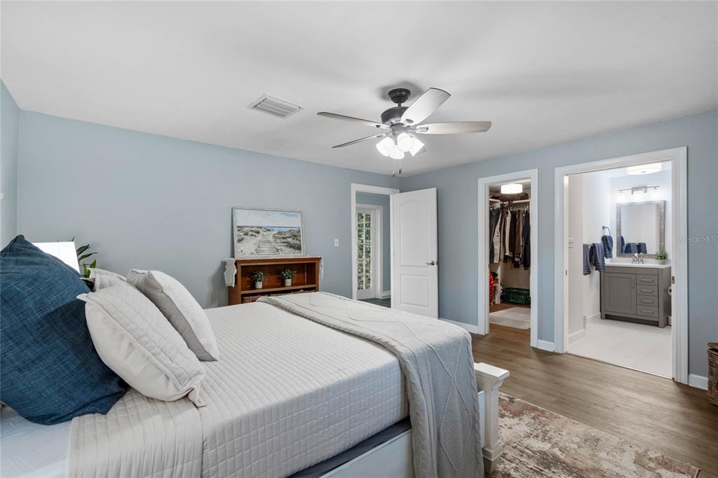 13830 Lake Mary Jane Road Orlando, FL 32832 - Photo 28 of 99 a bedroom with a large bed and a chandelier