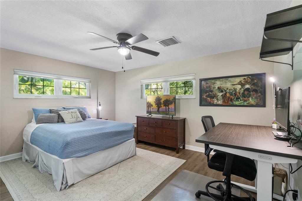 13830 Lake Mary Jane Road Orlando, FL 32832 - Photo 33 of 99 a bedroom with a large bed a desk and chair with a bookshelf