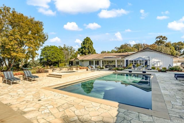 a view of house with outdoor space and swimming pool