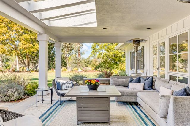 a living room with patio furniture and a floor to ceiling window