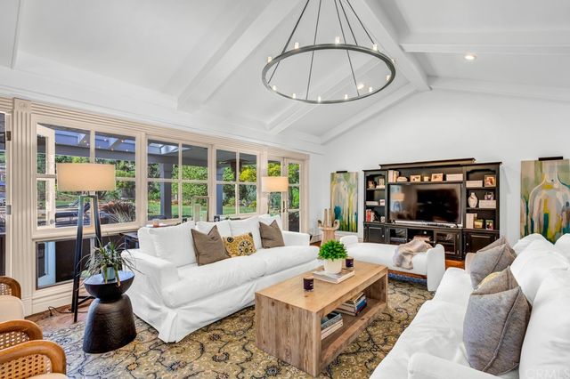a living room with furniture a flat screen tv and a large window