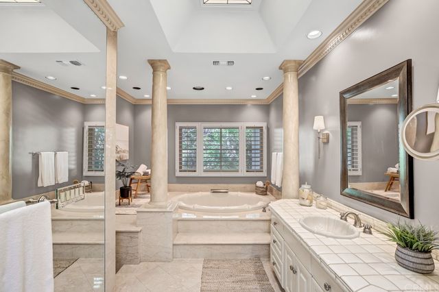 a spacious bathroom with a large tub sink and mirror