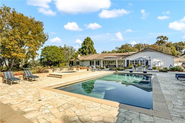 a view of house with outdoor space and swimming pool
