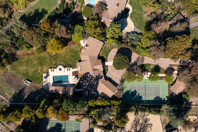 an aerial view of a house with a yard and lake view