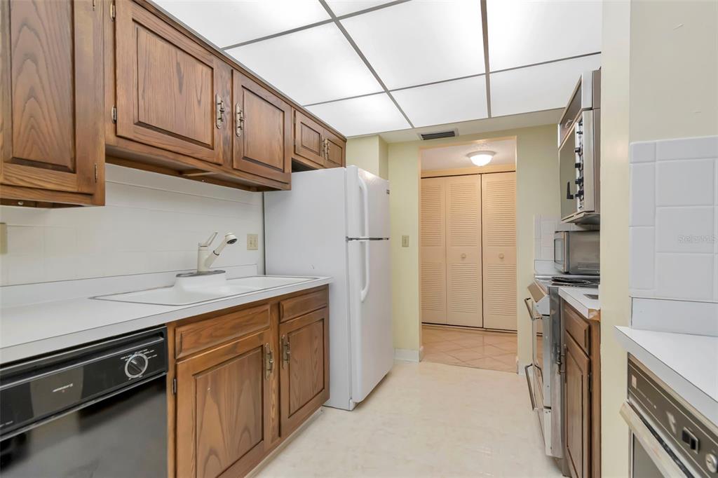 634 Edgewater Drive, Unit 848 Dunedin, FL 34698 - Photo 7 of 40 a kitchen with stainless steel appliances granite countertop a refrigerator a stove and a sink with cabinets