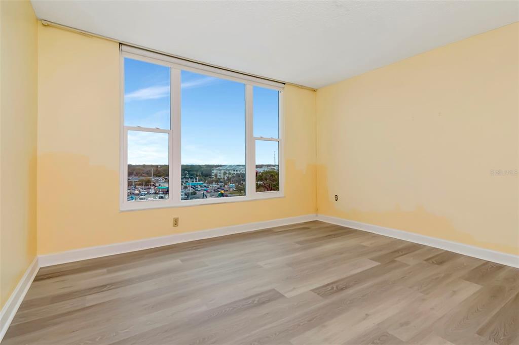 634 Edgewater Drive, Unit 848 Dunedin, FL 34698 - Photo 9 of 40 a view of an empty room with wooden floor and a window