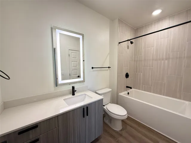 a bathroom with a toilet a sink a mirror and a bathtub