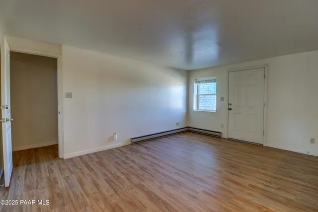 a view of empty room with wooden floor