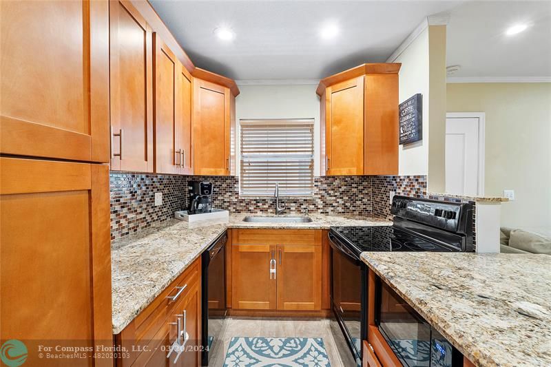 a kitchen with a granite countertop sink stove and cabinets
