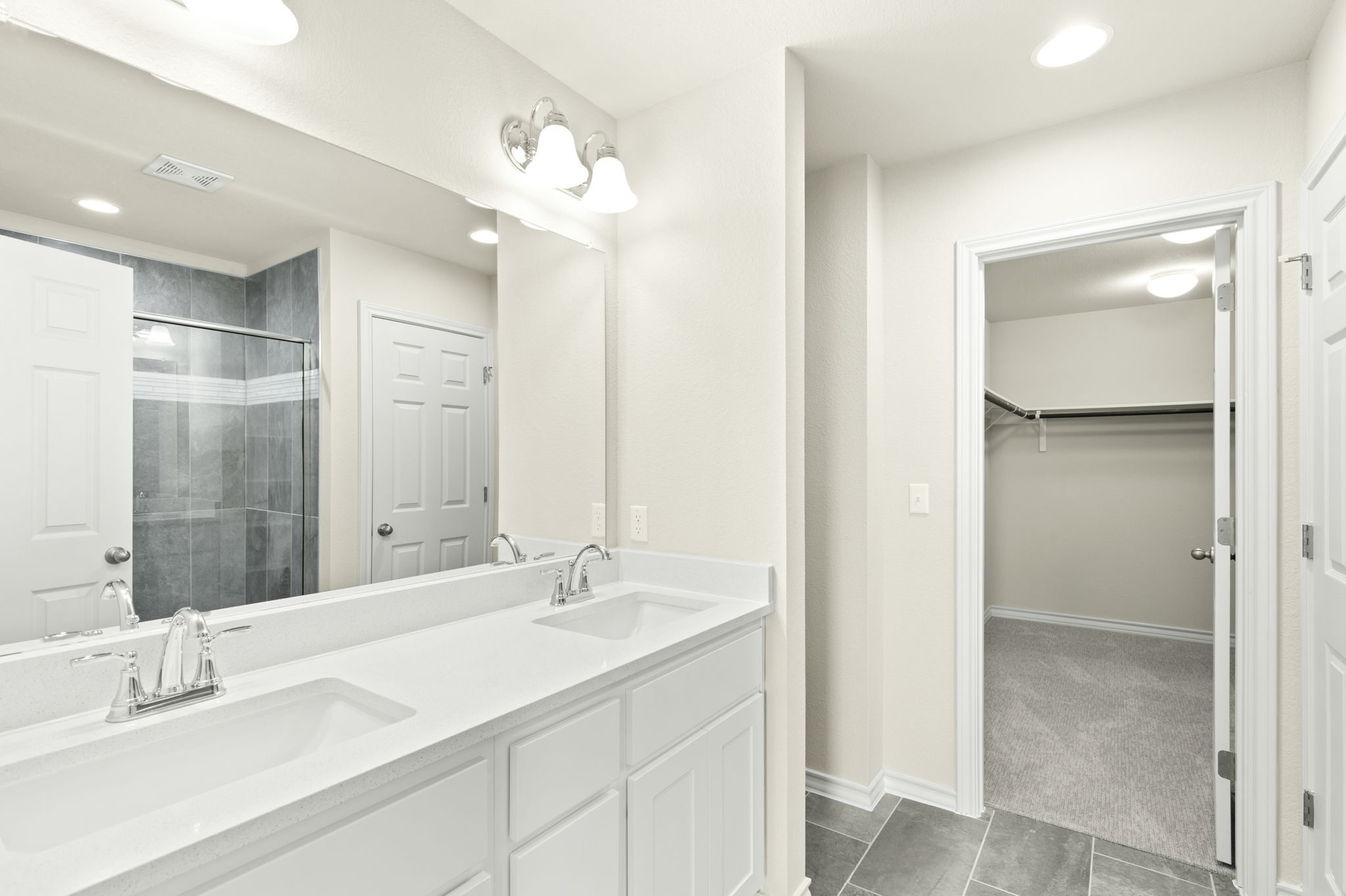 1624 Caballo Blanco Road Austin, TX 78725 - Photo 18 of 27 A spacious double vanity and tile flooring lead directly into a large walk-in closet.