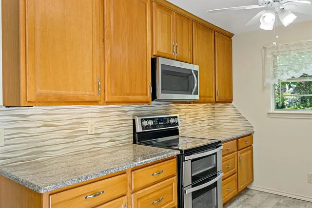 a kitchen with stainless steel appliances granite countertop a stove microwave and cabinets