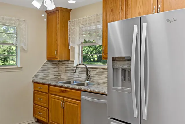 a kitchen with stainless steel appliances granite countertop a refrigerator and a sink