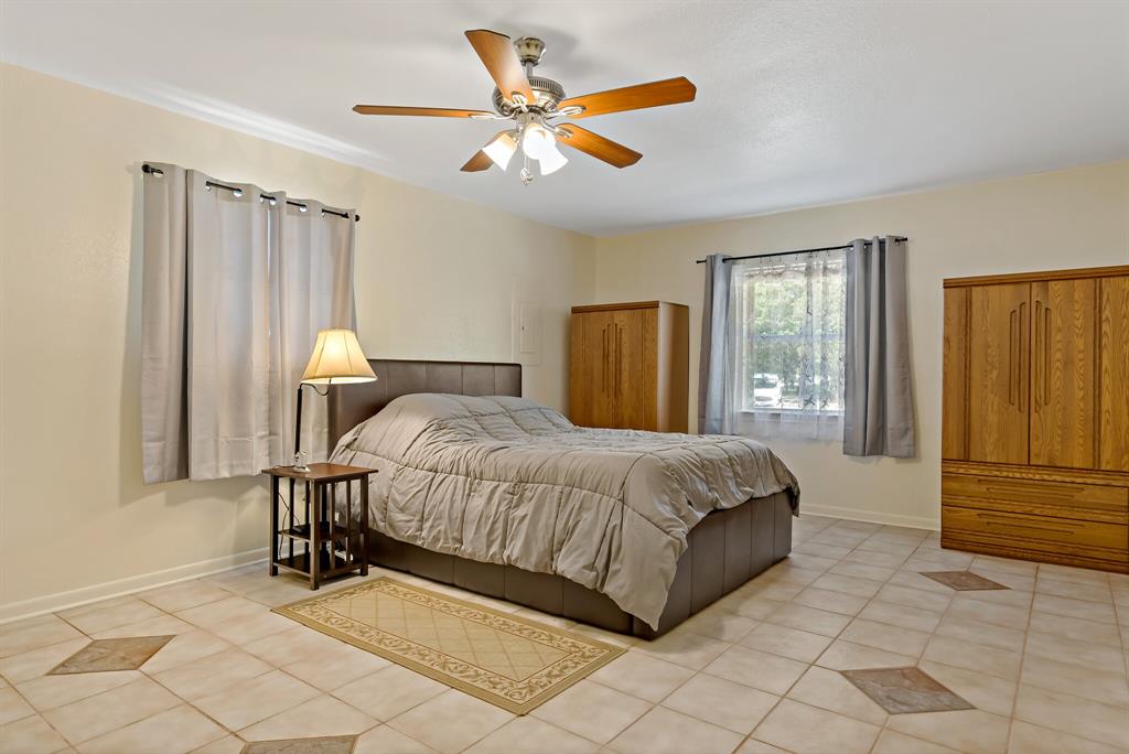 150 County Road Arthur City, TX 75411 - Photo 18 of 37 a spacious bedroom with a bed and a chandelier