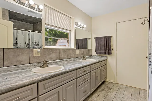 a bathroom with a sink double vanity granite and a mirror