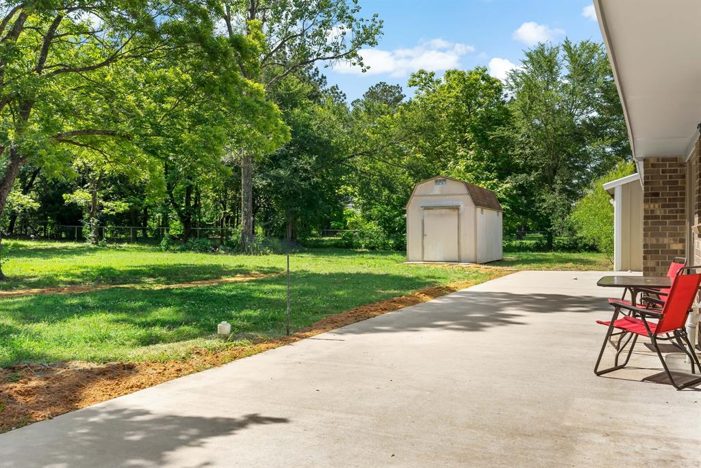 150 County Road Arthur City, TX 75411 - Photo 29 of 37 a view of a house with backyard and a tree