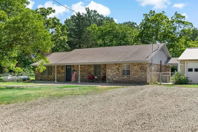 a aerial view of a house next to a big yard and large trees