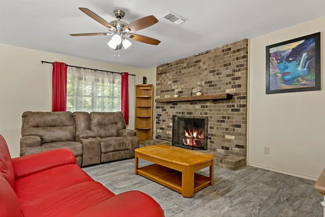 a living room with furniture a flat screen tv and a fireplace