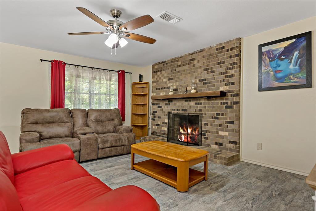 150 County Road Arthur City, TX 75411 - Photo 10 of 37 a living room with furniture a flat screen tv and a fireplace