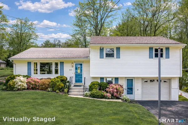 a front view of a house with a garden and plants
