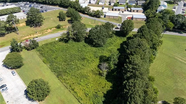 an aerial view of residential houses with outdoor space and trees all around
