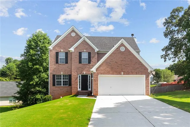 a view of a yard in front of a house with large trees