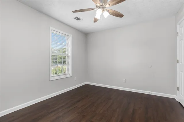 a bathroom with a granite countertop toilet sink and mirror