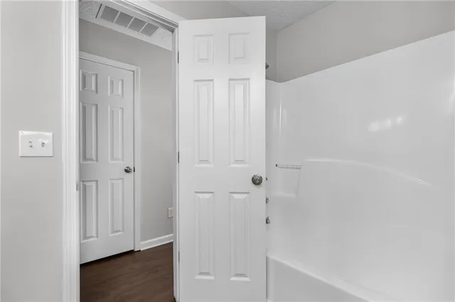 a view of an empty room with wooden floor