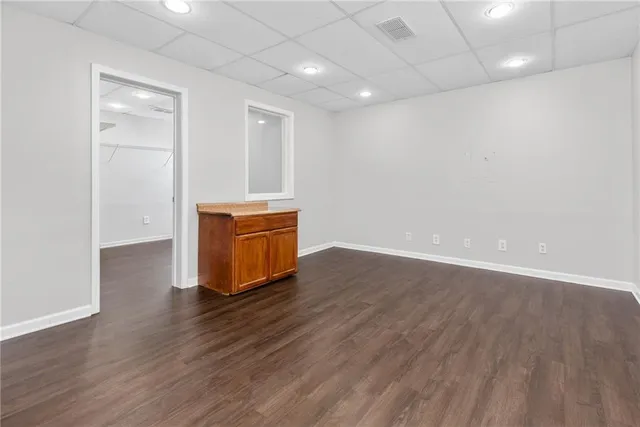 an empty room with wooden floor and mirror