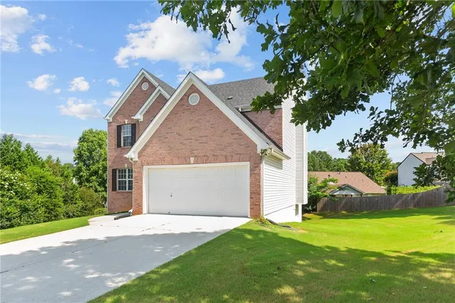 a view of a house with backyard and a tree