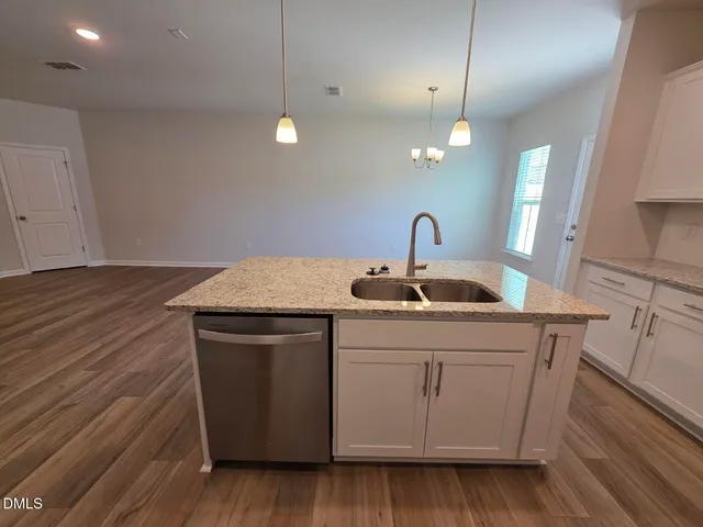 a kitchen with a sink and wooden floor