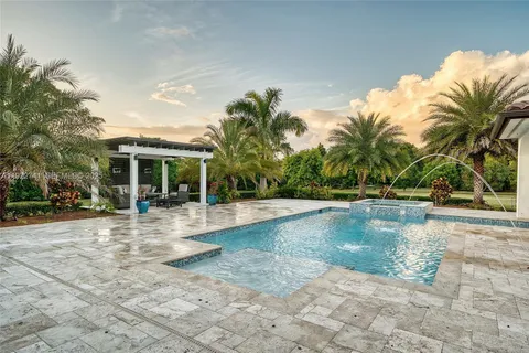 a view of a house with swimming pool and sitting area
