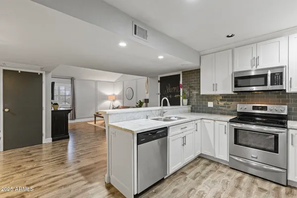a kitchen with a sink and steel appliances
