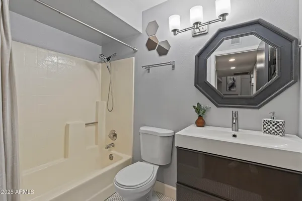a en suite bathroom with a toilet a sink and a mirror