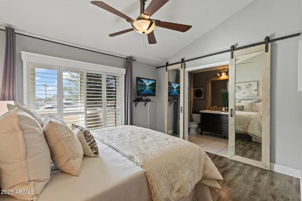 a bedroom with a bed dresser and a large window