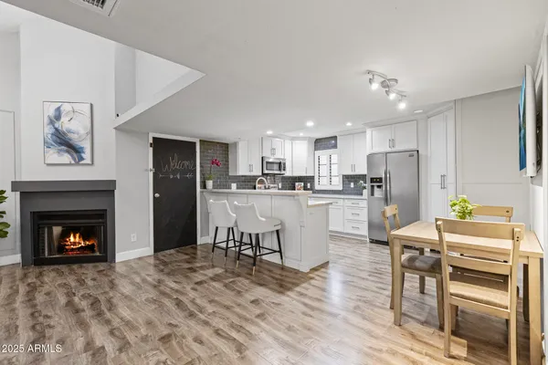 a kitchen with a table chairs refrigerator and cabinets