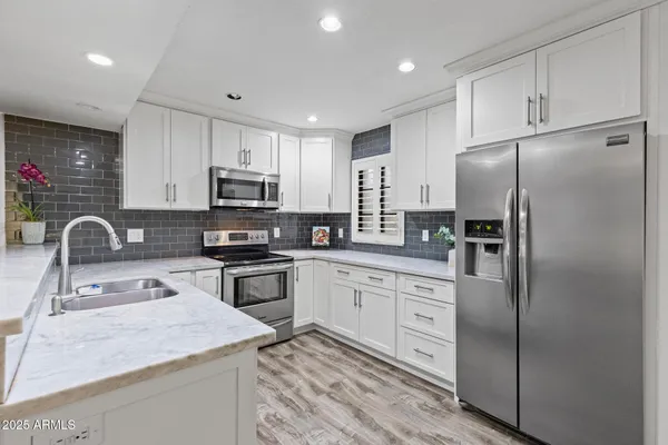 a kitchen with stainless steel appliances granite countertop a refrigerator sink and microwave