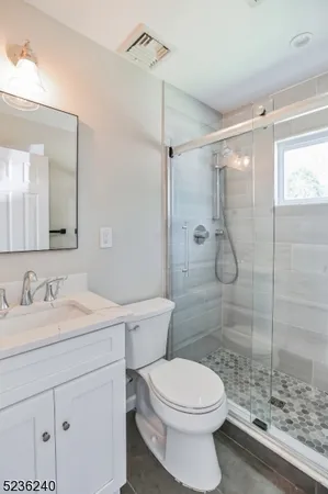 a bathroom with a sink double vanity granite and a toilet