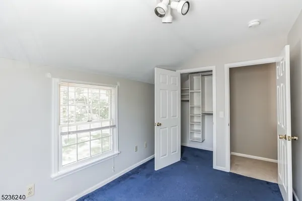 an empty room with windows and closet