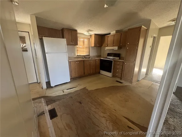 a kitchen with granite countertop a refrigerator and a sink