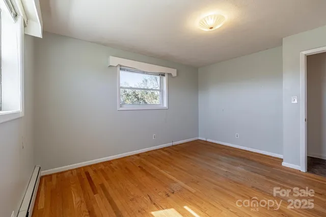 a view of room with window and wooden floor
