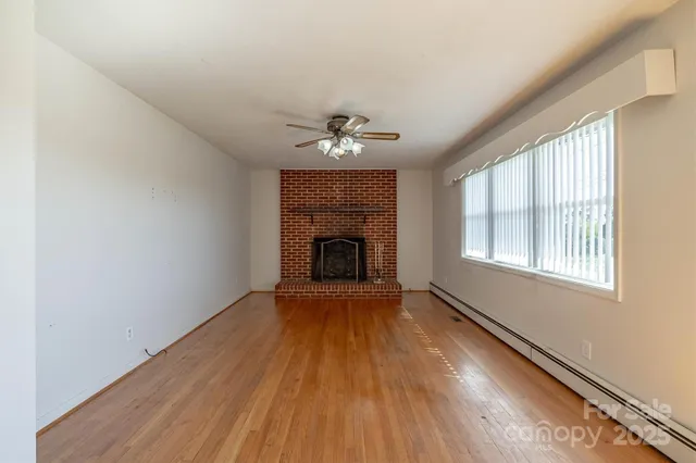 a living room with furniture a fireplace and a large window