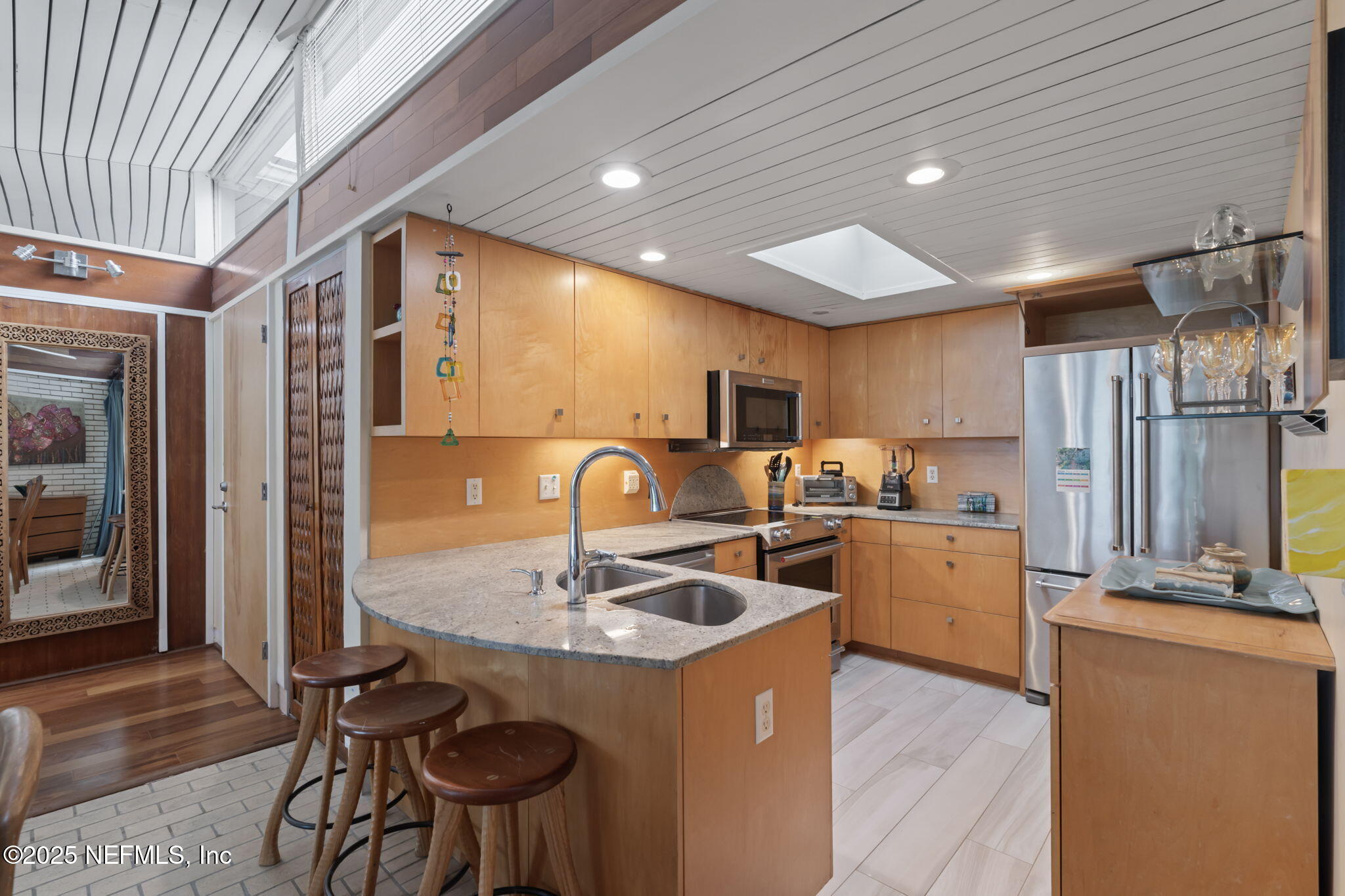 2337 Seminole Road, Unit B Atlantic Beach, FL 32233 - Photo 6 of 19 a kitchen with stainless steel appliances kitchen island granite countertop a sink refrigerator and cabinets