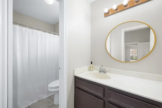 a bathroom with a sink a toilet and a mirror