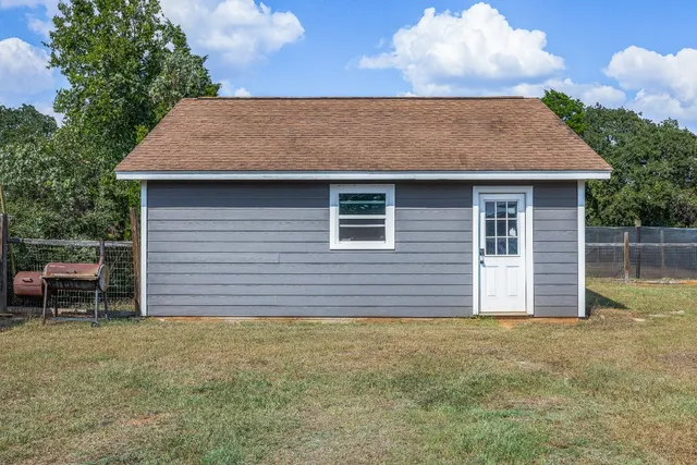 a backyard of a house with table and chairs