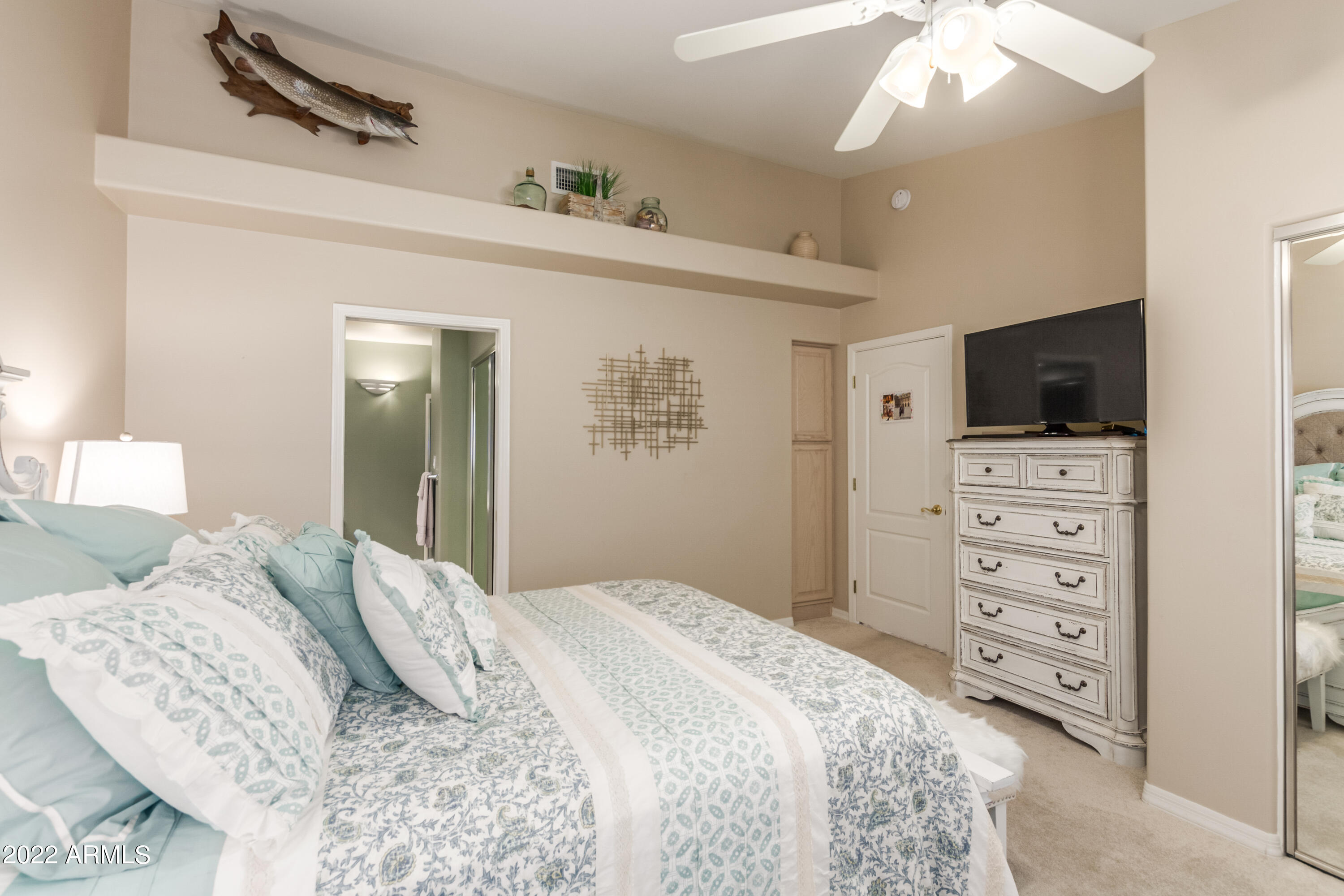 5830 East McKellips Road, Unit 76 Mesa, AZ 85215 - Photo 21 of 33 a bedroom with a bed and a flat tv screen on dresser