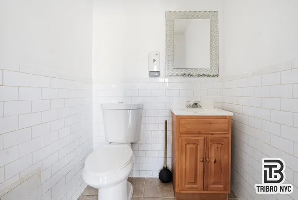 a bathroom with a toilet sink and mirror
