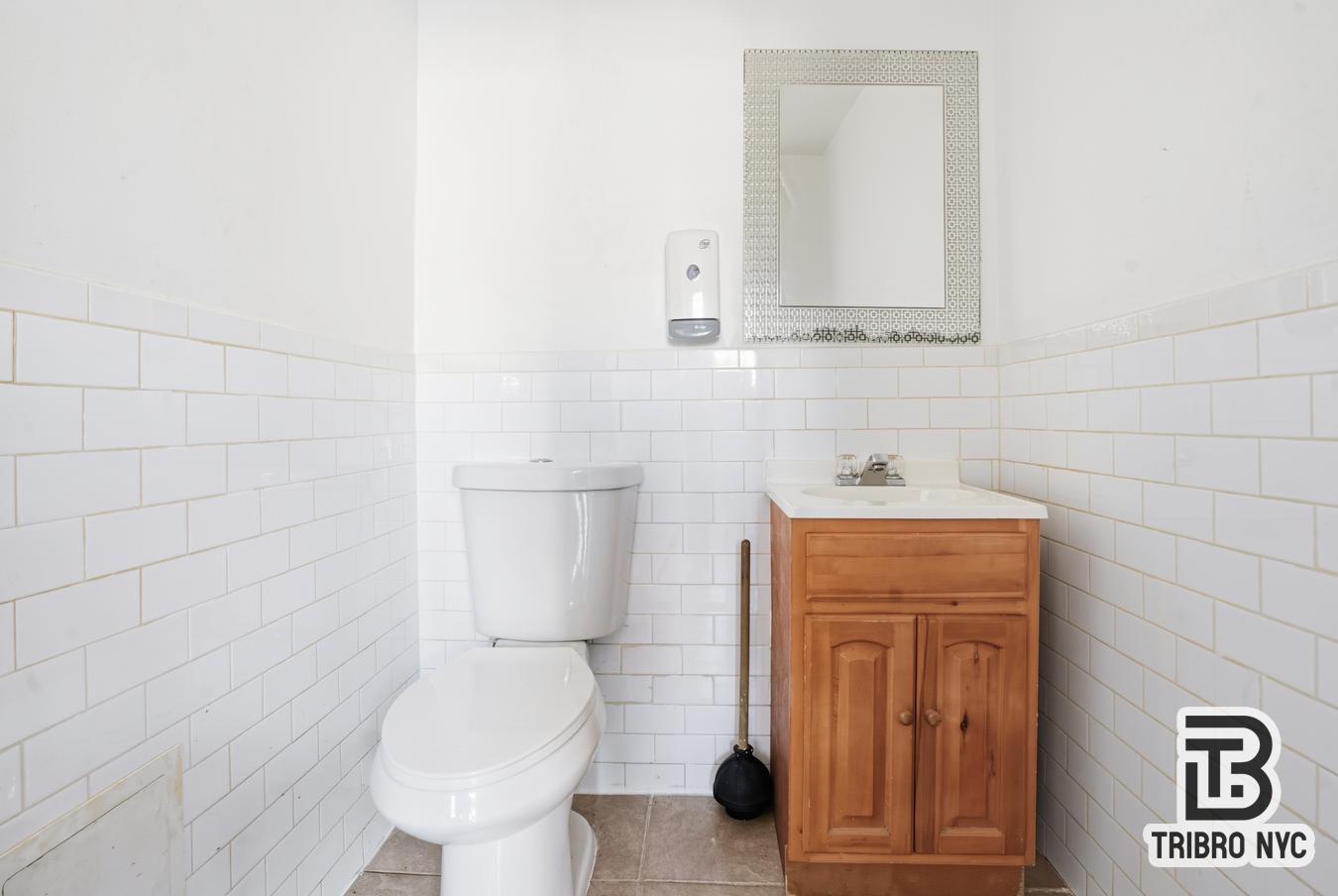 348 East 110th Street, Unit RETAIL Manhattan, NY 10029 - Photo 9 of 11 a bathroom with a toilet sink and mirror