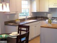 a kitchen with stainless steel appliances white cabinets and a table