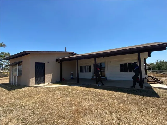 a view of a house with a yard and sitting area