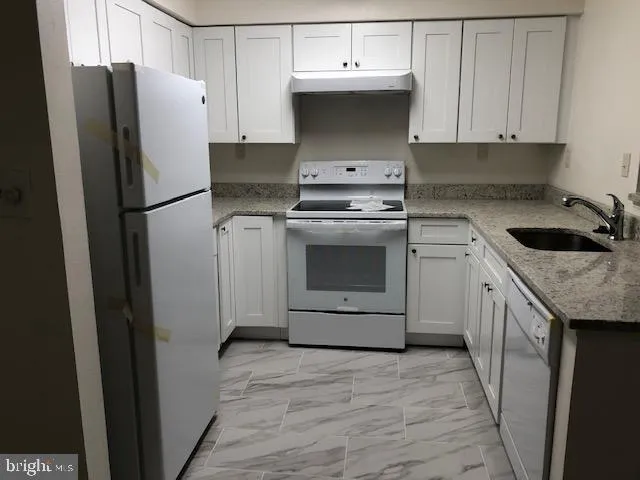 a kitchen with a sink stove and refrigerator